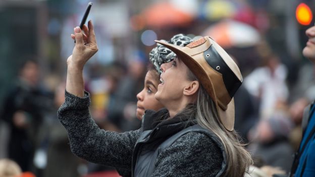 Mulher assiste à posse na Times Square, em Nova York