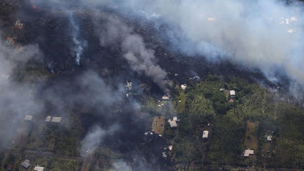 Lava from volcanic fissures slowly flows and overtakes structures and trees in the Leilani Estates neighborhood in the aftermath of eruptions from the the Kilauea volcano on Hawaii"s Big Island on May 6, 2018 in Pahoa, Hawaii.