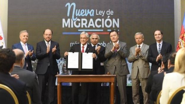 Piñera mostrando la nueva ley de migración.