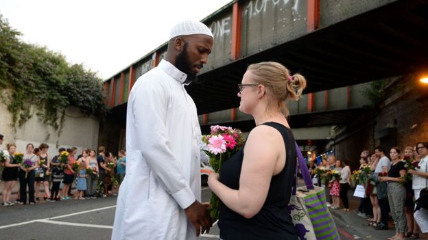 Joven entregando una flor a un joven musulmán
