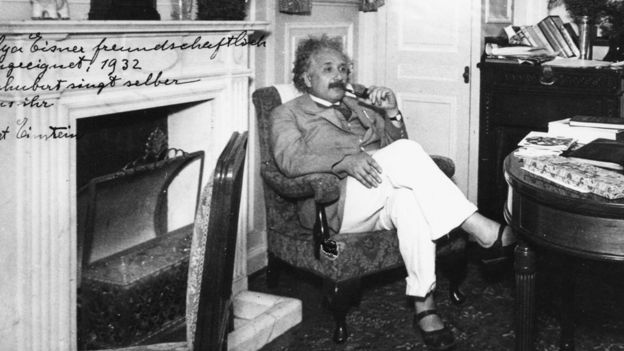 Albert Einstein, sentado, en sandalias
