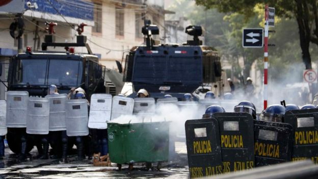 Vehículos de la policía y agentes escudados forman una línea para impedir que los manifestantes avancen al Congreso.