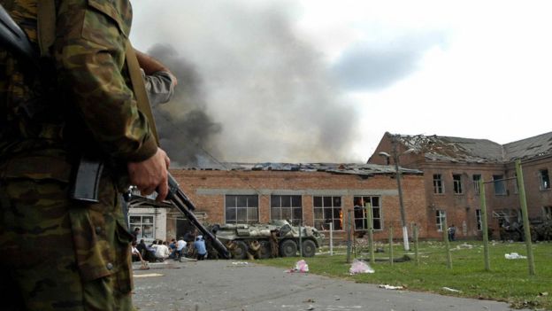 Soldiers and security forces are seen in front of the burning school during the rescue operation in Beslan, northern Ossetia