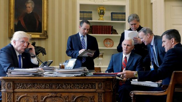 Trump hablando por teléfono rodeado por su equipo de gobierno al principio de su mandato.