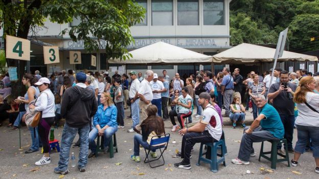 Filas de votantes ante un centro de votación.