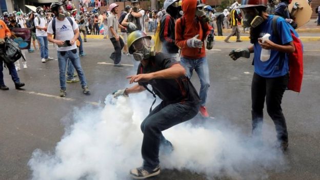 A demonstrator prepares to throw a tear gas canister during riots at a rally against Venezuelan President Mauro's government in Caracas, Venezuela, June 7, 2017.
