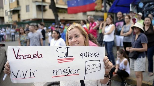 Mujer con un cartel a favor de la consulta