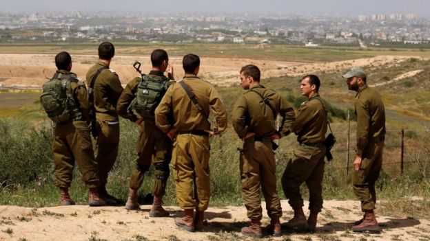 Israeli soldiers listen to a briefing on the Israeli side of the border with the northern Gaza Strip on 29 March, 2018.