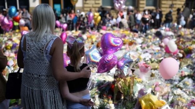 People gather to see flowers and messages of support in St Ann