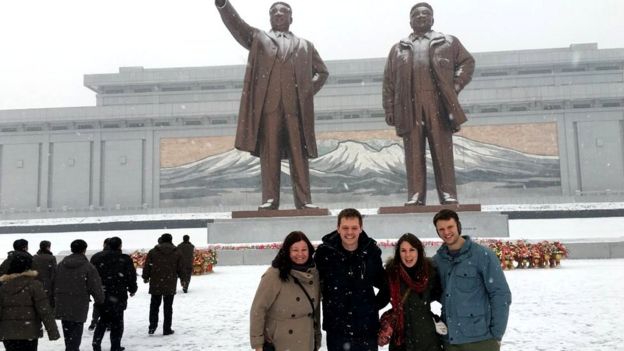OttoWarmbier and friends pose in front of statues in North Korea