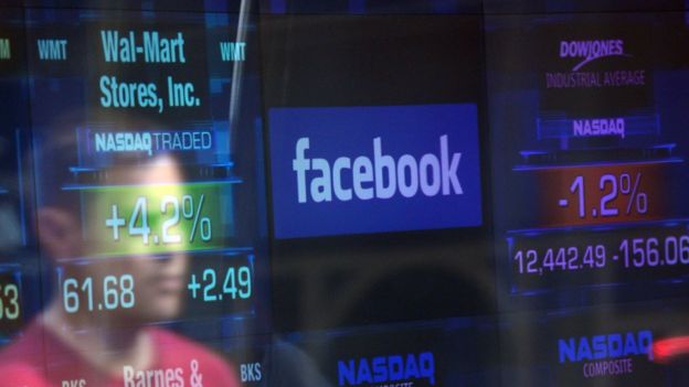 Pantalla con números y precios de acciones más el logo de Facebook.