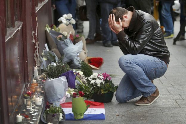 A man pays his respect outside the Le Carillon restaurant the morning after a series of deadly attacks in Paris (14 November 2015)