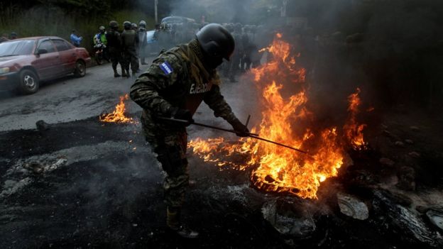 Un soldado extingue un fuego en Tegucigalpa.