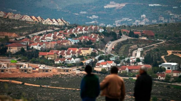 People stand in front of the Jewish settlement of Shvut Rachel during a tour organised by the Palestinian authorities for ambassadors based in Tel Aviv and consuls based in Jerusalem on March 16, 2017