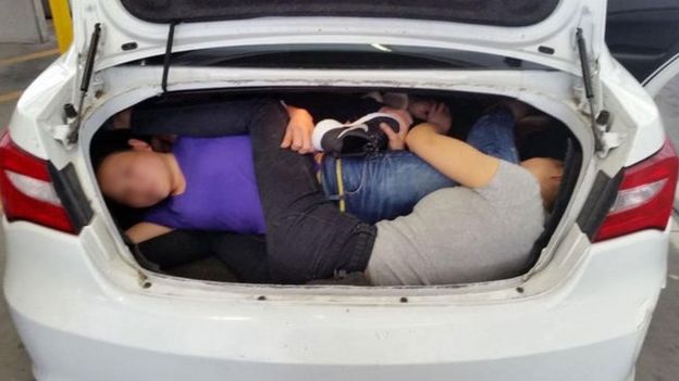 Cuatro personas en la maletera de un auto.
