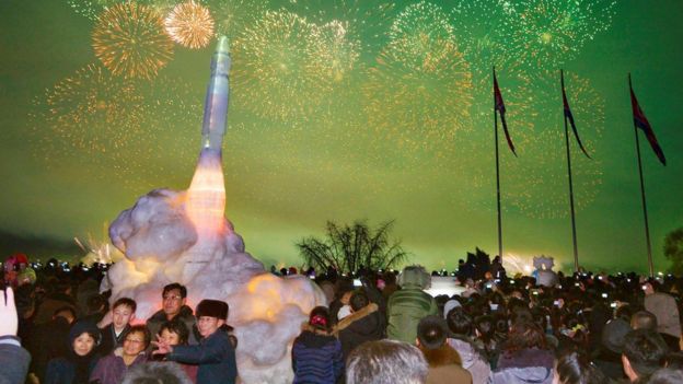 Visitors pose for a photo in front of an ice sculpture of an intercontinental ballistic missile at the Pyongyang Ice Sculpture Festival in Pyongyang, 31 Dec 2017