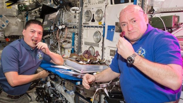 Los astronautas Scott Kelly y Kjell Lindgren comiendo ensalada