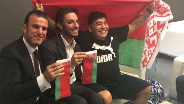 Марадона с белорусским флагом в руках и двумя участниками подписания контракта