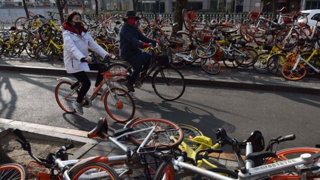 Gente manejando bicis en Pekín en 2018.