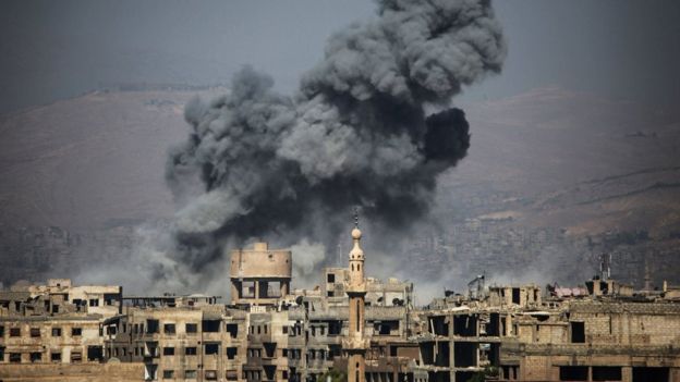 Smoke rises from buildings following an air strike on the rebel-held town of Ayn Tarma, in Syria's Eastern Ghouta area, on July 7, 2017