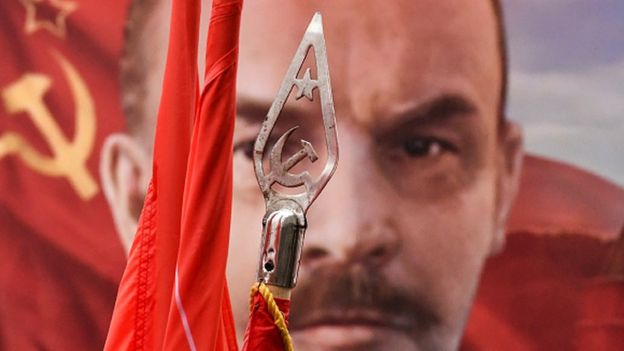 Red flags and a portrait of the Soviet Union founder Vladimir Lenin from a 7 November rally