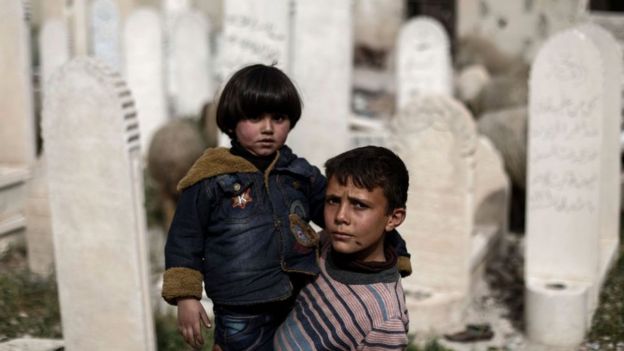 Şam yakınlarında bir mezarlıkta kaybettikleri yakınlarını ziyaret eden iki çocuk