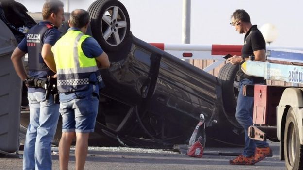 Policemencheck the car involved in the attack in Cambrils