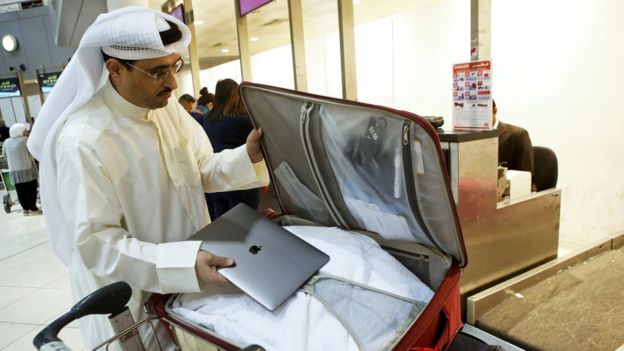 Diz üstü bilgisayarını bavuluna yerleştiren Kuveytli bir yolcu
