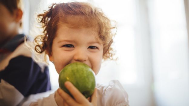 Niña comiendo una manzana