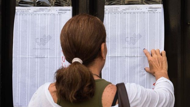 Una mujer busca su nombre en el registro de electores en Venezuela.