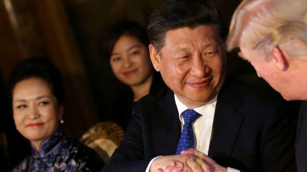 Chinese President Xi Jinping shakes hands with U.S. President Donald Trump as he is accompanied by China