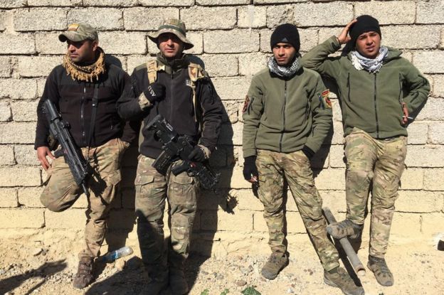 Soldiers rest during the offensive in southern Mosul