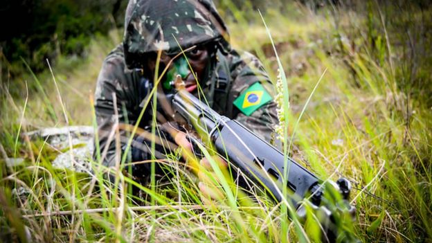 Militar com arma em punho