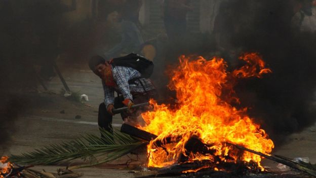 Un manifestante junto a una barricada incendiada en Nochixtlán