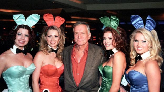 Hugh Hefner con cuatro mujeres en uniformes Playboy