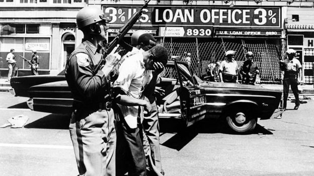 Police officers arrest black suspects on a Detroit street on 25 July 1967.