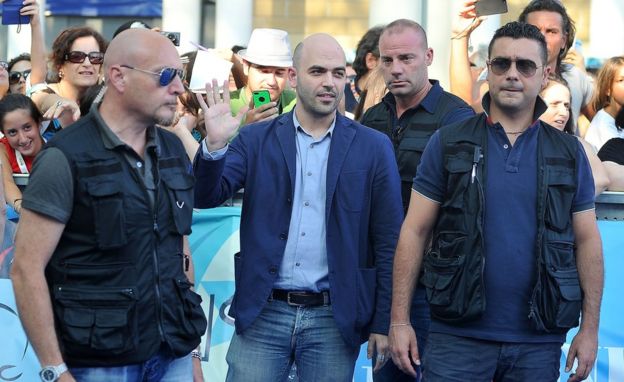 Roberto Saviano (centro) junto a seguranças.