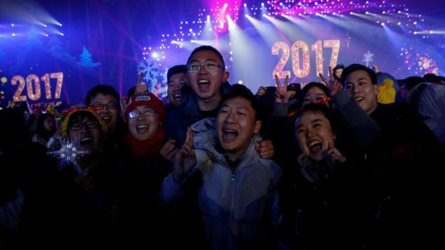People pose for pictures as they attend a New Year
