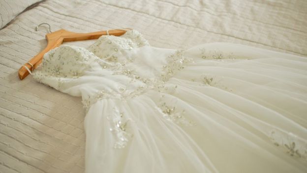 A wedding dress on a bed