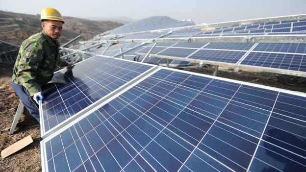 Un trabajador instala un panel solar en China.