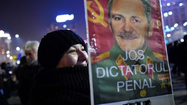 Una mujer protesta en Rumania con un cartel en contra de Liviu Dragnea