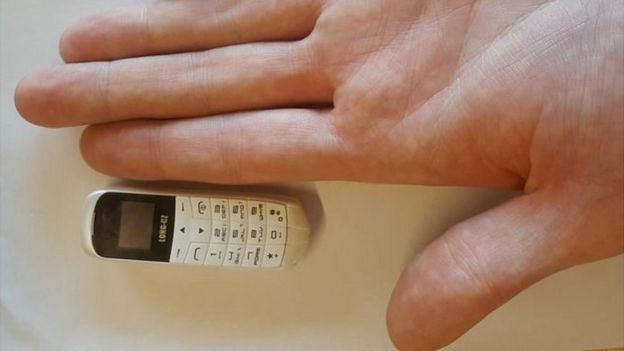 Imagen de un mini celular comparado con la palma de una mano.