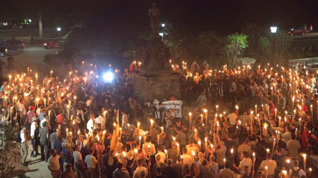 White nationalists carry torches around a statue of Thomas Jefferson on the grounds of the University of Virginia, surrounding a smaller group of counter protesters, 11 August 2017