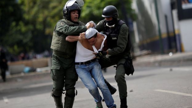 Miembros de las fuerzas de seguridad de Venezuela arrestan a un manifestante opositor