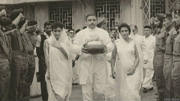 கர்னல் தாராபோரின் அஸ்தி கலசத்தை எடுத்துச் செல்லும் மனைவியும் மகளும்