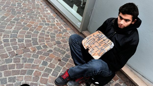 Un joven pide dinero en la calle en Francia.