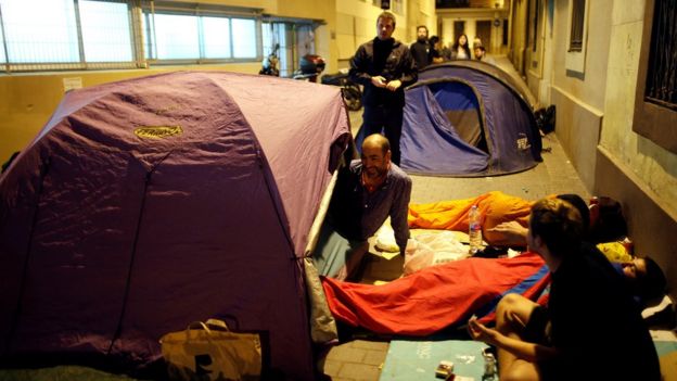 Parents camp out at the entrance of the occupied Reina Violant elementary school, one of the designated polling stations, the night before the banned October 1 independence referendum in Barcelona, Spain