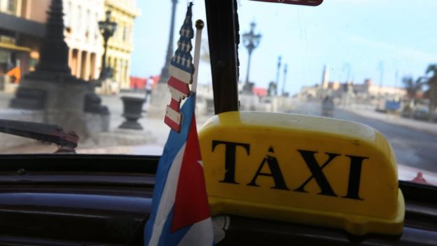 La vista desde dentro de un taxi en La Habana. El aromatizador que cuelga del espejo retrovisor es un arbolito con la bandera de Estados Unidos.