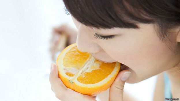 Joven comiendo una naranja