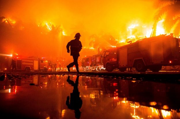 Firefighters work at the scene of a fire at Kandawgyi Palace hotel in Yangon early on 19 October 2017.